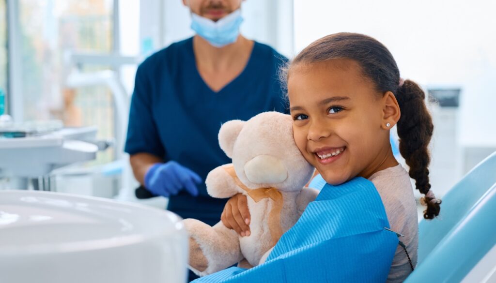 Young girl holding a teddy bear in an orthodontist office, featured in a Gavri Orthodontics blog post.